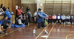 Angus Erueti smacks the ball during an indoor softball game.