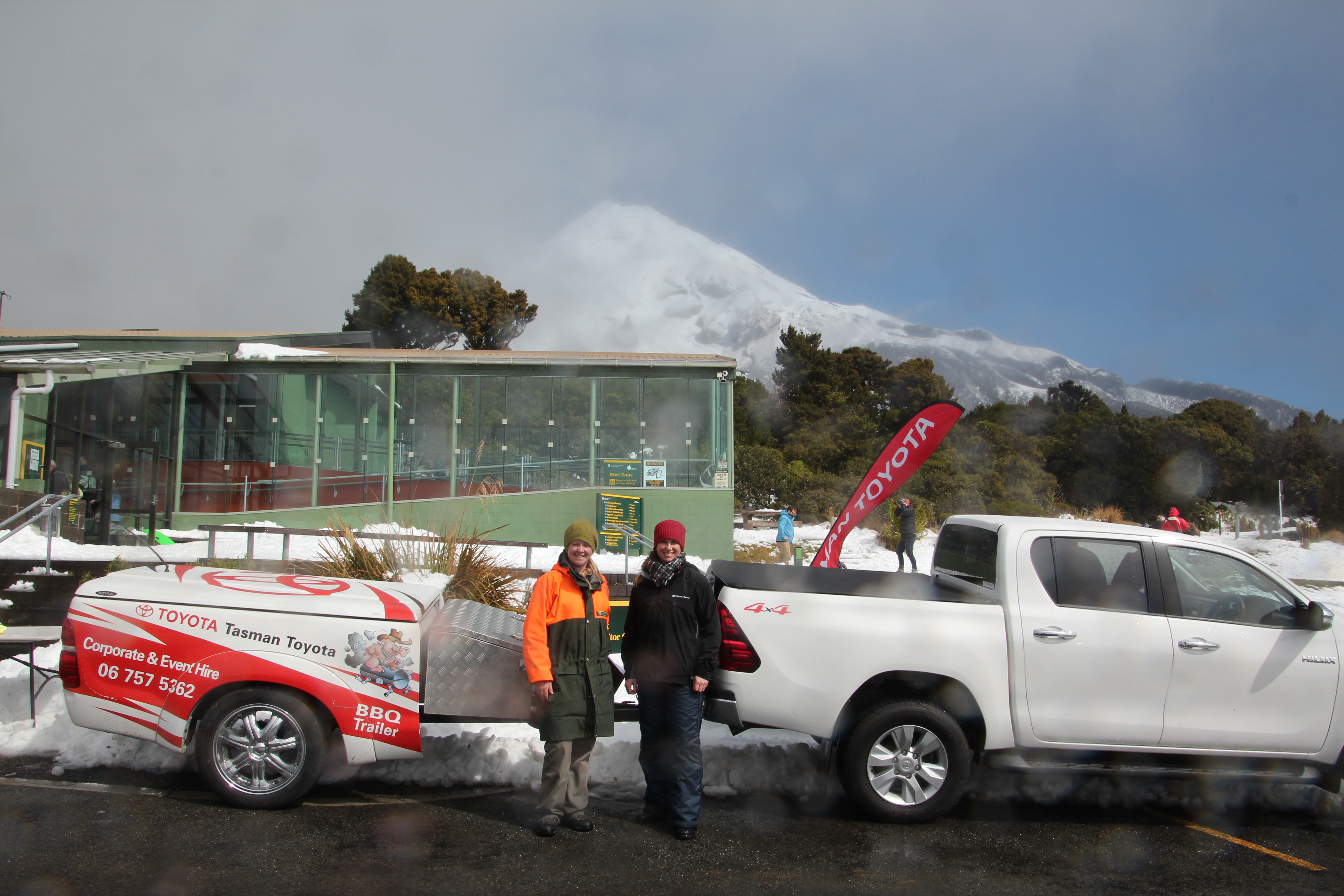 Mt Egmont / Mt Taranaki peeking out from cloud with DOC Ranger Denise Goodman and Tasman Toyota Customer Relationship Manager in New Plymouth Vanessa Sumpter.